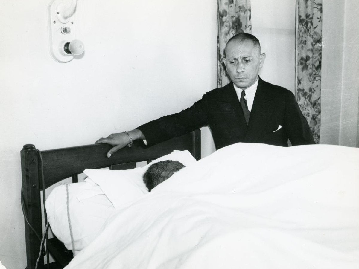Nach dem Feuerunfall seiner Frau, Valerie Germonprez, an ihrem Krankenbett, 1933
